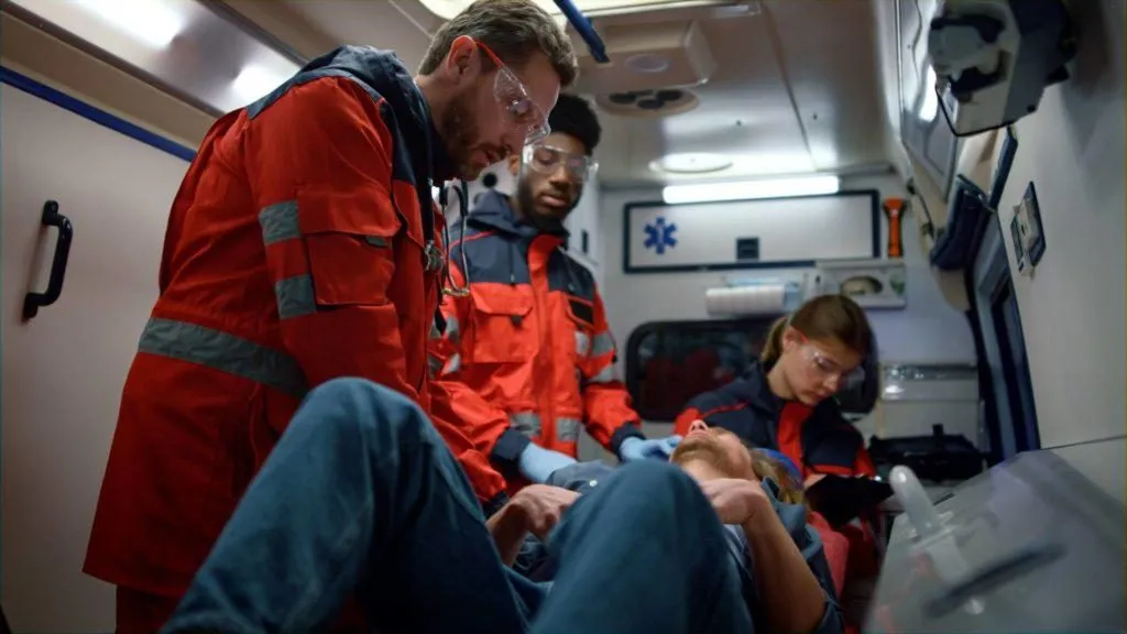 Paramedics treating a patient inside an ambulance